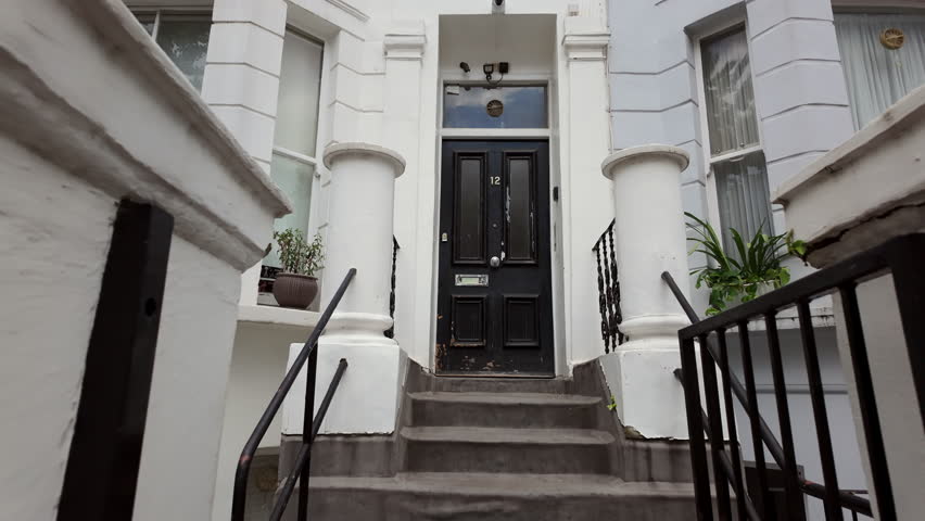 Beautiful vintage black color door leading into the house. Entrance to the living space from the street with a nice door and steps.