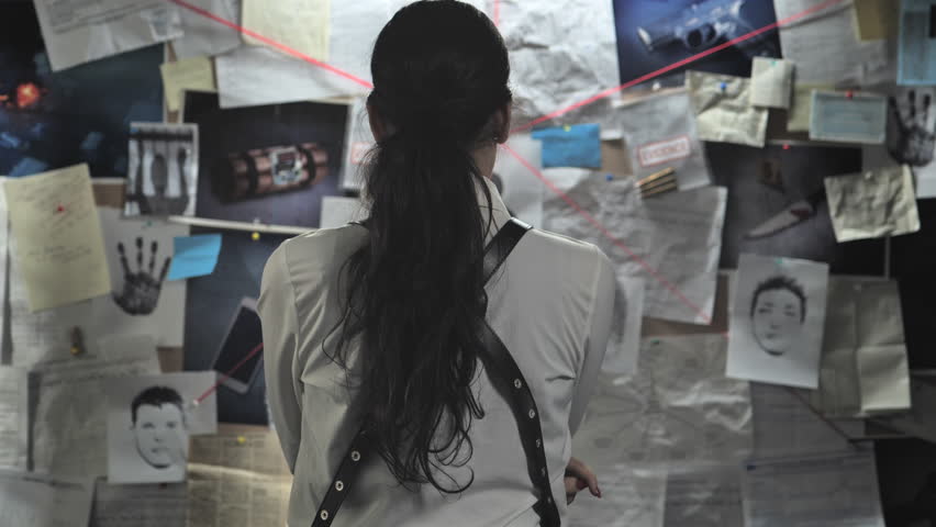back view of pensive police detective looking at evidence board in office,caucasian policewoman investigates on criminal case examining crime clues