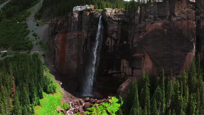Summer green Telluride Bridal Veil Falls Waterfall Colorado powerplant house aerial drone Box Canyon Black Bear Pass Road Rocky Mountains 4wd hiking blue sky cliffs Uncompahgre Forest backwards pan up
