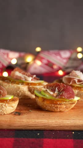 Vertical video, Christmas food, Spanish tapas of Serrano ham on an American oak board, Christmas backgrounds, blurred background