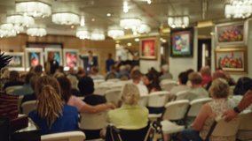 Crowd gathers in a blurred art gallery auction, featuring colorful paintings, with men and women seated attentively in a focus on vibrant, out-of-focus, dynamic cultural experience. - Powered by Shutterstock - Get 15% off with code: PIKWIZARD15