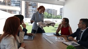Business team taking a break with pizza in a modern office setting. Engaged in informal discussion while laptops and documents remain open. Sunlit room with cityscape view - Powered by Shutterstock - Get 15% off with code: PIKWIZARD15