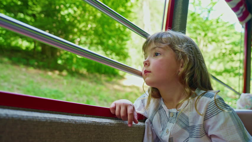 Little girl ride in the famous red rotary steam train leaving the town of Brienz in the Swiss Alps along the alpine meadows to the top of a mountain in summer. Switzerland