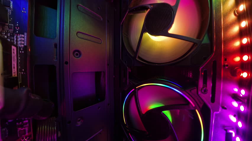 A dolly shot inside a gaming PC, moving closer to reveal vibrant RGB-lit cooling fans and detailed hardware components. The smooth motion highlights the illuminated and high-tech setup, creating an im