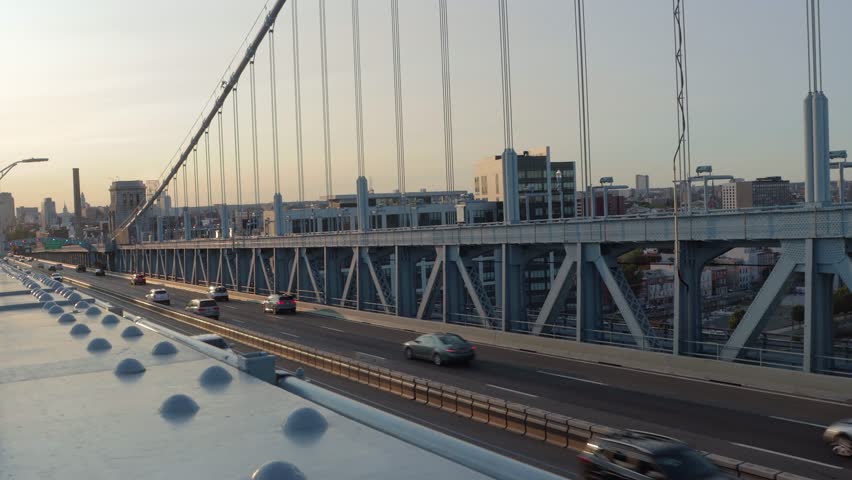 Evening Traffic Driving Across a Suspension Bridge at Sunset in Philadelphia, Pennsylvania.