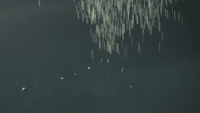 Uncooked semolina cereal pouring on black background slow motion - Powered by Shutterstock - Get 15% off with code: PIKWIZARD15