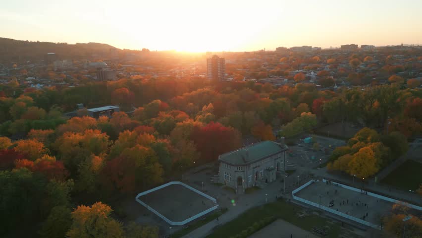 aerial shot in Parc Lafontaine in Montreal city at sunset revealing montreal downtown buildings and Mont Royal in the background during fall season, Quebec, Canada
