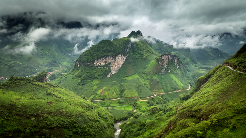Drone hyperlapse toward karst outcrop and swirling mountain fog, north Vietnam