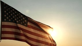 Veterans Day, Memorial Day. Silhouettes of American flag waving in the sky against sunset or sunrise background. Concept of US Holidays 4th of July, Independence Day, Veterans Day, Celebration, Labor - Powered by Shutterstock - Get 15% off with code: PIKWIZARD15