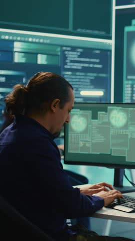Vertical Video Cyber security experts in a governmental hacking room working on securing networks. Hackers focusing on malware detection, cyber operations and protection against digital mercenaries