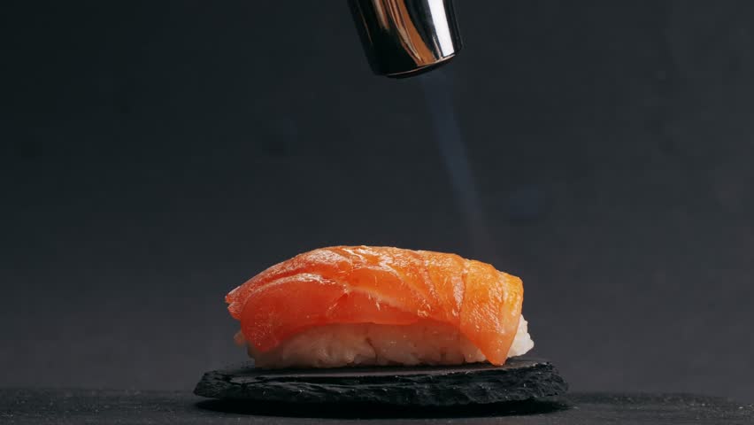 Chef cooking Sashimi Nigiri Platter with flambe fire, japanese sushi restaurant, Fresh Tuna and Salmon Slices in modern cafe, traditional food, raw red fish dish, omega 3.
