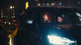Handsome young man opens a car door on a rainy night for his female partner, offering her an umbrella as she exits. Their child sits inside. Concept of chivalry, gentlemanly gesture and romance - Powered by Shutterstock - Get 15% off with code: PIKWIZARD15