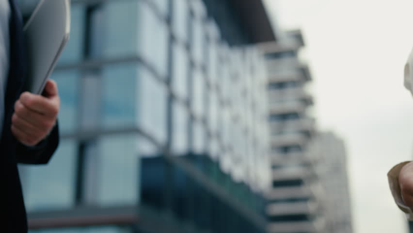 Close up unrecognizable multiracial business meeting in city colleagues Caucasian businessman man male guy African woman businesswoman girl female handshaking shake hands formal greeting hold folder