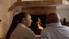 Older black couple by wood fireplace enjoy together. Senior people inside cabin home on winter time - Powered by Shutterstock - Get 15% off with code: PIKWIZARD15