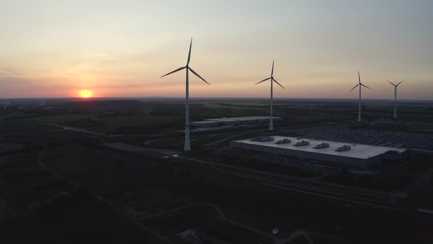 Drone footage of spinning windmills in a vast field, showcasing renewable energy production, wind power efficiency, and the role of sustainable technology in modern energy solutions and business growt