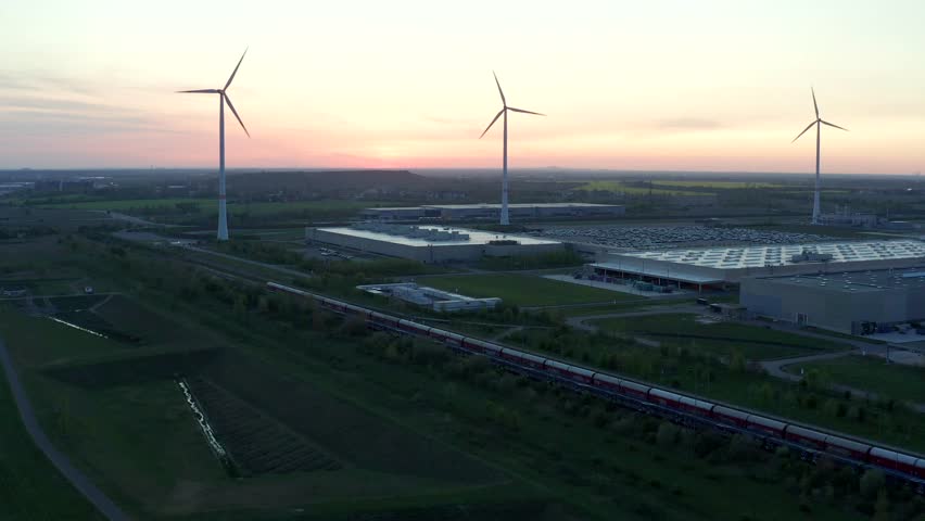 Drone footage of spinning windmills in a vast field, showcasing renewable energy production, wind power efficiency, and the role of sustainable technology in modern energy solutions and business growt