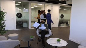 Businessman is sitting in the lobby of his office building, reviewing some documents while waiting for his colleagues to arrive for a meeting - Powered by Shutterstock - Get 15% off with code: PIKWIZARD15