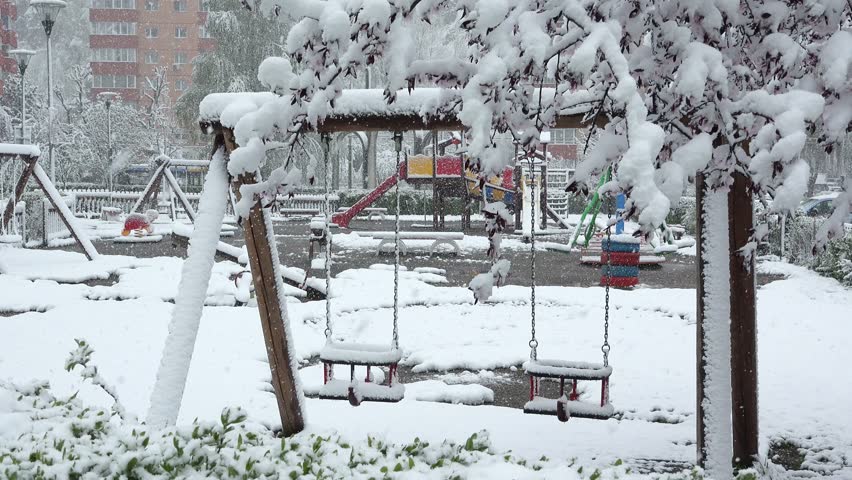 Swing in the park covered with snow in winter