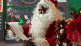 Black Santa opening and reading letters sitting cozy in his log cabin. Winter holiday season brings the magic of wish lists, presents and tradition, spreading Christmas spirit. Camera A. - Powered by Shutterstock - Get 15% off with code: PIKWIZARD15