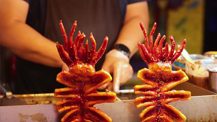 Vendor grilling squid skewers at Hong Kong market