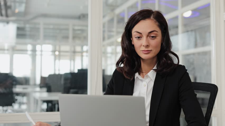 Busy 30 years old business woman entrepreneur working in office checking documents in office. Businesswoman account female manager executive or lawyer using laptop computer at work.