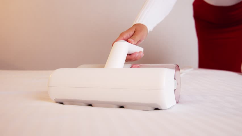 Remove Dust Mites From Mattress With UV Vacuum Cleaner. Woman