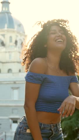 Beauty latin sensual and happy woman dancing in a view point against sunset with church on the background