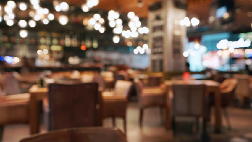 Blurred cozy stylish restaurant interior with warm ambient lighting empty tables. Soft bokeh effect highlights relaxed atmosphere perfect for social gatherings quiet moments. Food drink people