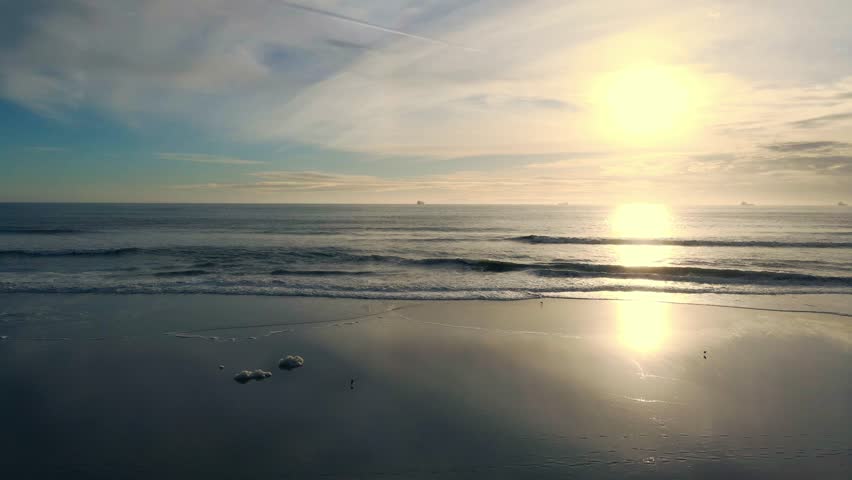 Aerial view of serene ocean waves at sunset with a picturesque horizon and tranquil sky, Huntington Beach, United States of America.