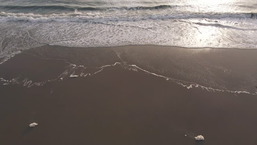 Aerial view of beautiful sunset over tranquil ocean waves at Huntington Beach, California, United States of America.