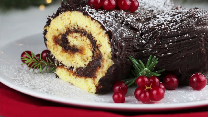 Buche de Noel, Chocolate Christmas Yule Log. Christmas light on a white background. Traditional Christmas dessert. 
