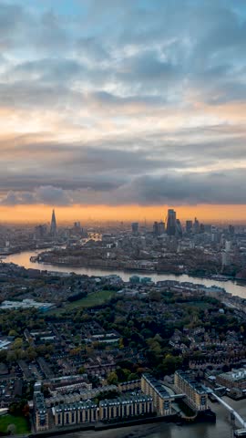 Moody sunset to night time lapse view of the London skyline with sun, clouds and rain showers