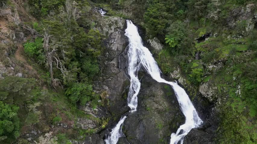 An aerial footage of the scenic Taheke Waterfalls during daytime in Whareora, Northland, New Zealand