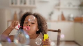 Child playing with soap bubbles, portrait of charming black baby girl at home. Carefree and happy childhood, African American ethnicity, mixed race family, flying bubbles in slow motion, children game - Powered by Shutterstock - Get 15% off with code: PIKWIZARD15