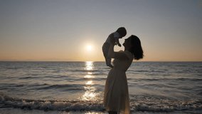 Sunset silhouette of mother rising up the baby on the beach - Powered by Shutterstock - Get 15% off with code: PIKWIZARD15