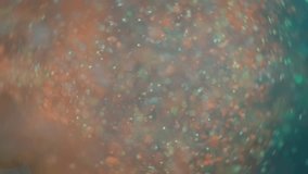 Teal and orange glitter particles burst in slow motion.  - Powered by Shutterstock - Get 15% off with code: PIKWIZARD15