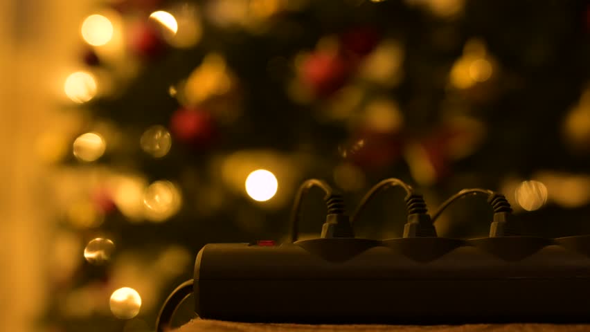 Turning on and off garlands on christmas tree. Christmas decorations, switching on christmas lights, festive mood with beautiful illuminations