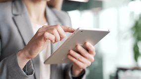 Close up of female hands holding using digital tablet in business office. Businesswoman in a suit working on application, banking, reading or typing message, chatting online, browsing, checking email - Powered by Shutterstock - Get 15% off with code: PIKWIZARD15