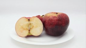 Super time lapse of two apples dehydrating and going bad after placing on porcelain white plate and left in lightbox or under controlled lighting condition against white background for 21 days - Powered by Shutterstock - Get 15% off with code: PIKWIZARD15