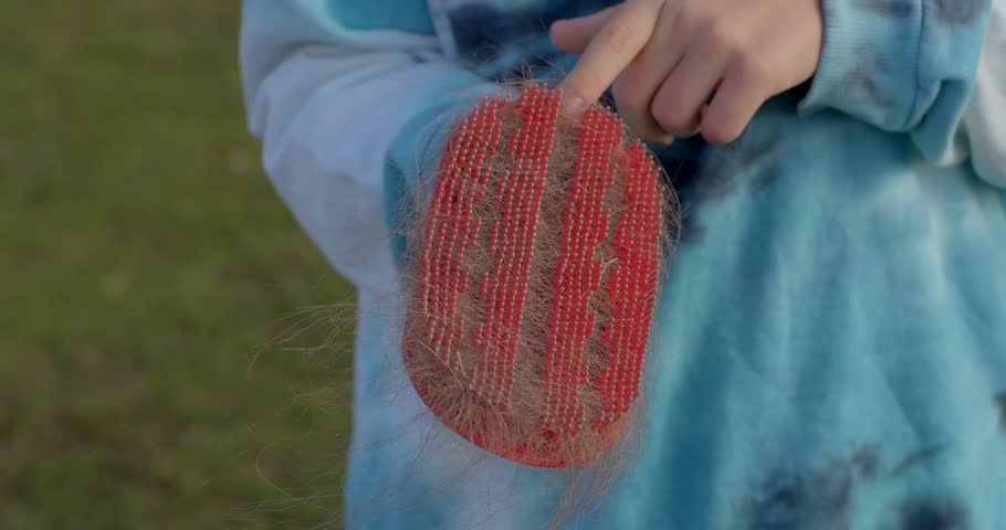 A cheerful child holds a vivid red paddle in a lively outdoor setting, showcasing energy and playfulness