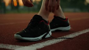 Runner. Active man outdoors purposefully tying shoelaces on sports field. Steady camera movement Caucasian white man putting on running shoes warming up before competition, exercise - Powered by Shutterstock - Get 15% off with code: PIKWIZARD15