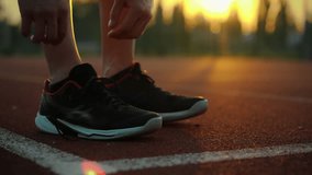 Healthy lifestyle. Active man in sports gear ties shoelaces on a special field. Steady camera movement disciplined athlete puts on running shoes leads an active lifestyle, movement - Powered by Shutterstock - Get 15% off with code: PIKWIZARD15