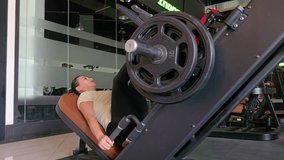 Leg press, Machine exercise, 40 year old woman. Attractive female gym trainer doing leg press exercise. - Powered by Shutterstock - Get 15% off with code: PIKWIZARD15