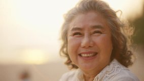 4K Portrait of Happy Asian senior woman relaxing and looking beautiful nature of tropical island beach at sunset. Elderly woman enjoy outdoor lifestyle travel at the sea on summer holiday vacation. - Powered by Shutterstock - Get 15% off with code: PIKWIZARD15