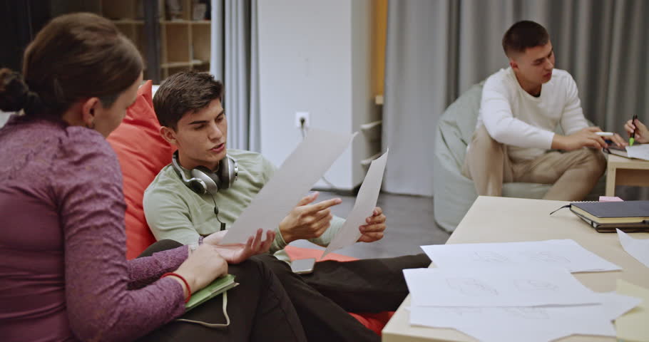 Students and a professor study geometry together during class. They discuss and point at diagrams and equations on paper. The learning and teaching process continues after regular school hours.