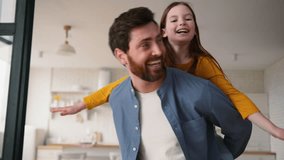 Smiling Caucasian daughter dad male daddy having fun guy girl dancing together enjoying weekend playing at home little kid piggyback ride happy father man carry child family laughing leisure childcare - Powered by Shutterstock - Get 15% off with code: PIKWIZARD15