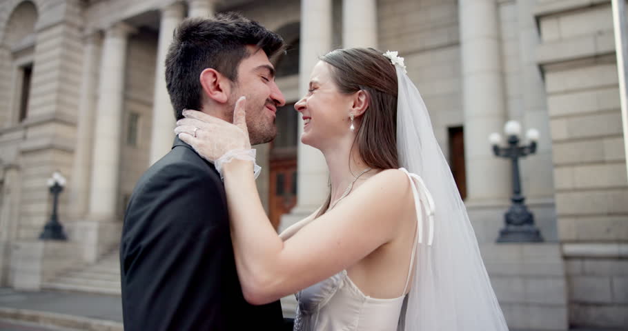 Couple, kissing and marriage at city hall with loyalty, commitment and wedding celebration outdoor. Bride, groom and happy people by courthouse for civil union, love ceremony or romantic relationship