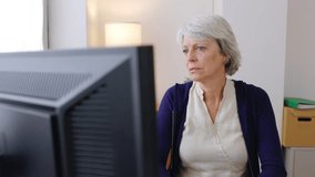 Senior adult businesswoman working on desktop PC at home office. Business concept. - Powered by Shutterstock - Get 15% off with code: PIKWIZARD15