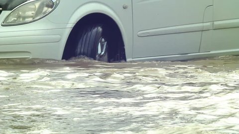 Flooded road after heavy rains,cars moving slowly in deep waters. vehicle sequence. 