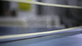 Ping pong ball bouncing close to the net on a table during a fast-paced game. Focus on the net and ball in motion, showing the intensity of the sport in an indoor environment - Powered by Shutterstock - Get 15% off with code: PIKWIZARD15
